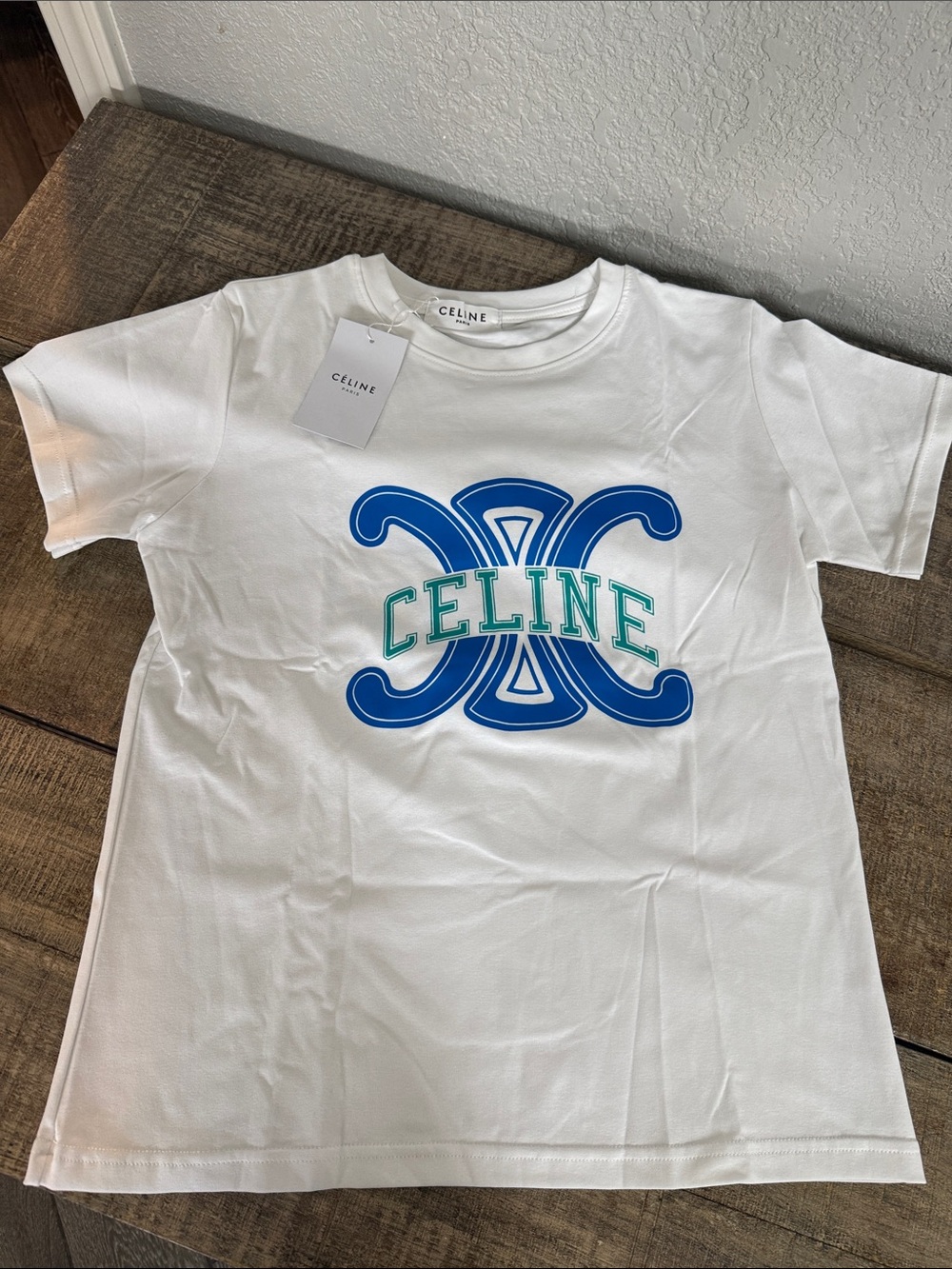 Women’s Cel  White Stretch Tee with Blue & Green Emblem